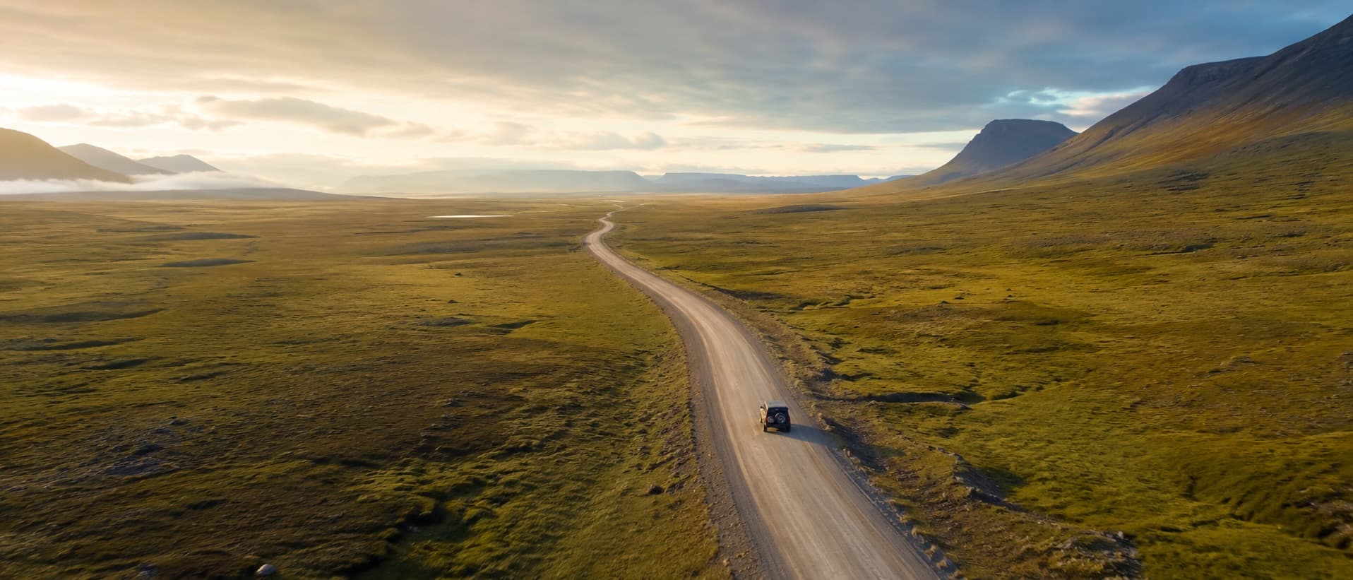 Drone Shot von Geländewagen in der Natur auf Schotterstraße